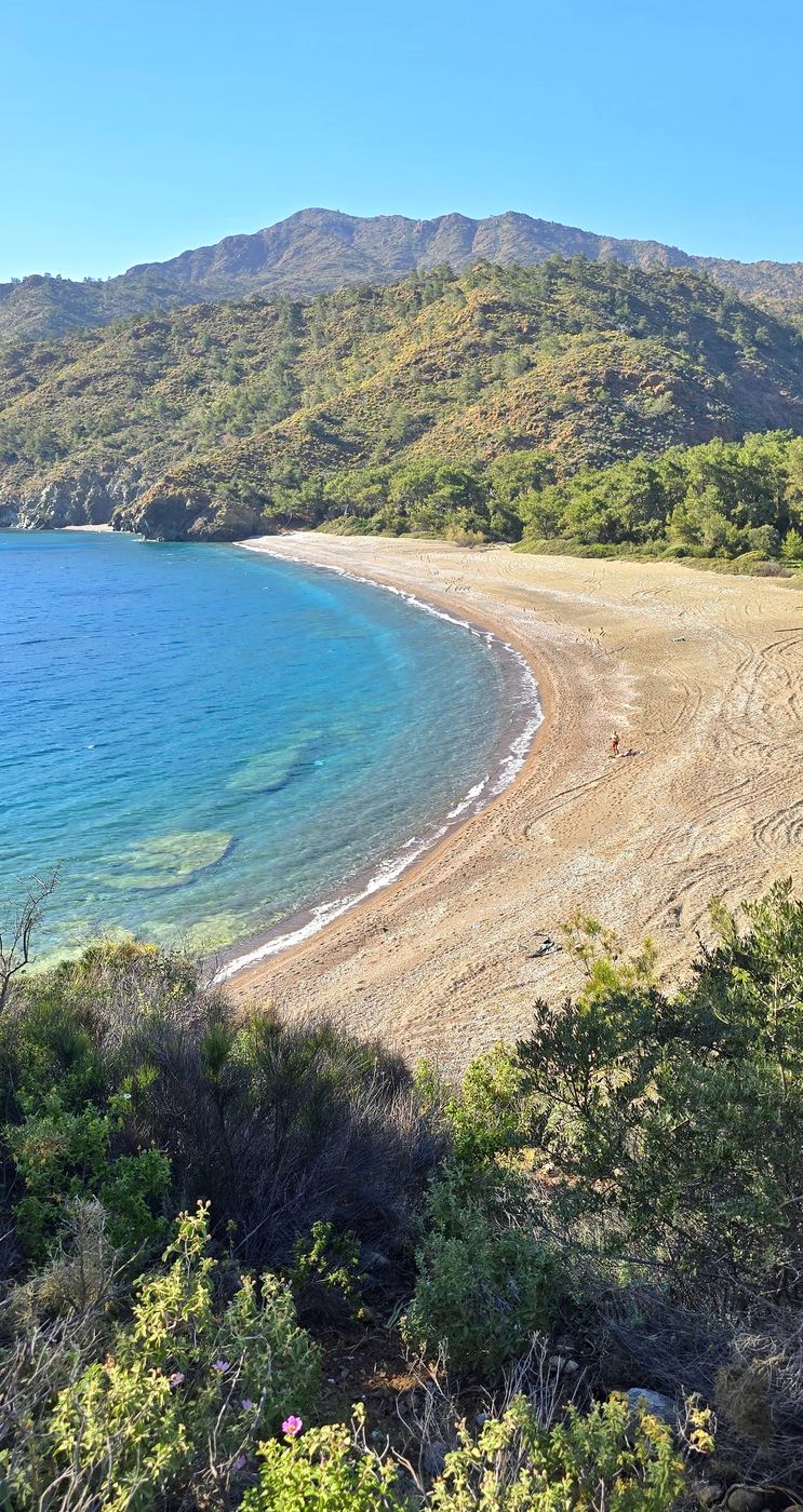 Langer Kiesstrand am Fuß der Berge